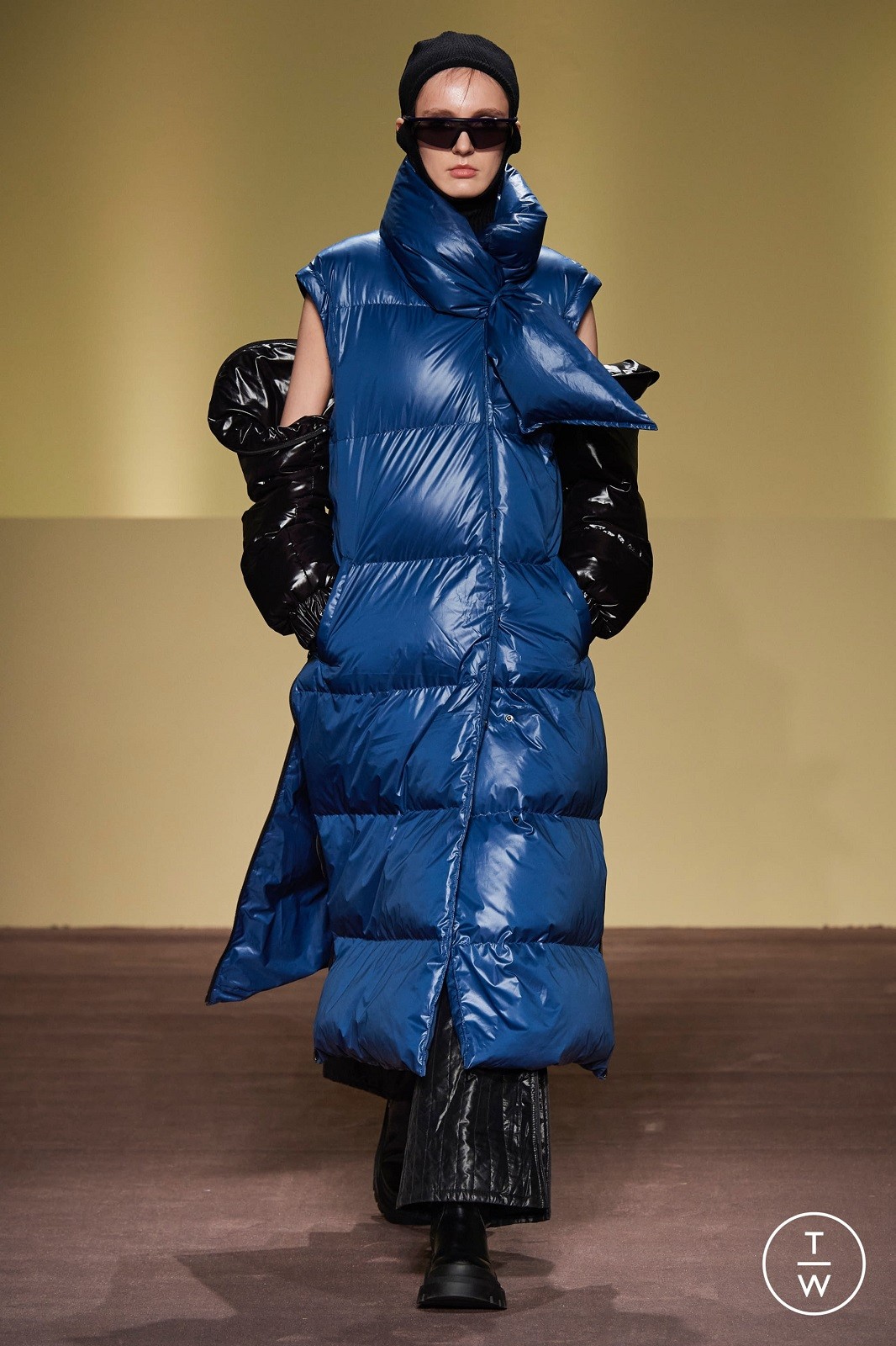 Γυναίκα σε catwalk με μπλε μακρύ φουσκωτό μπουφάν