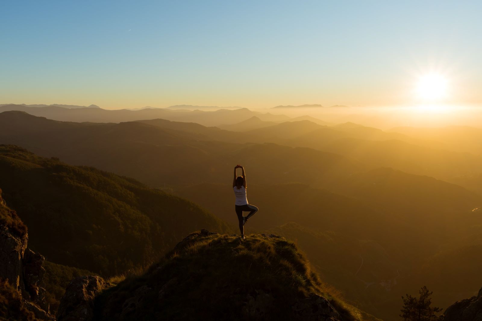 Yoga στην κορυφή βουνού βλέποντας τον ήλιο