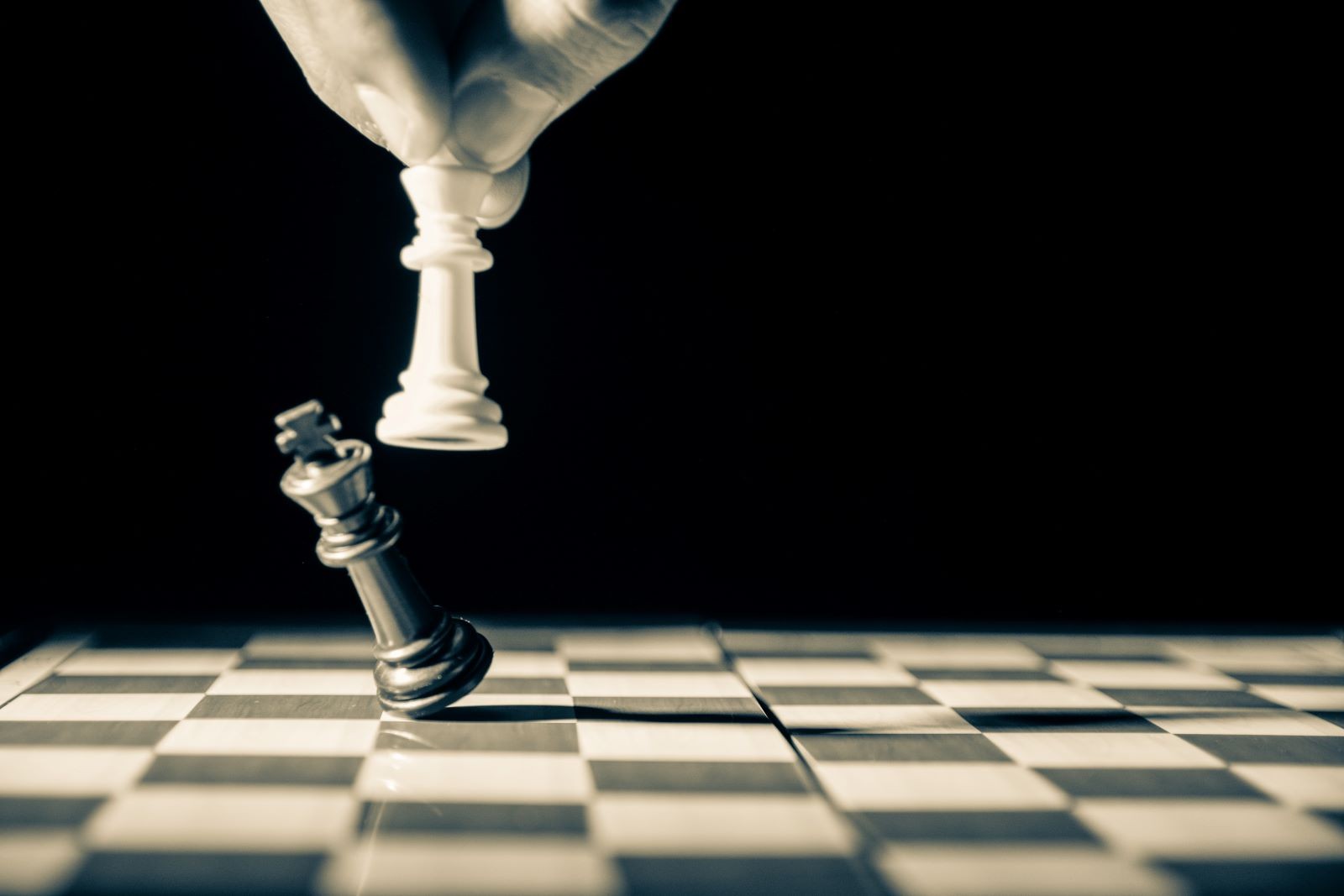 Λευκό πιόνι βασιλιά στο σκάκι ρίχνει μαυρό πιόνι βασιλιά