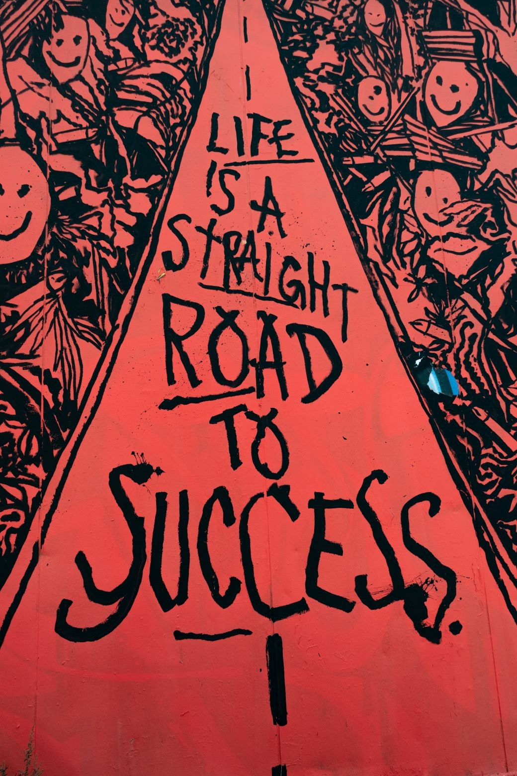 Ζωγραφιά από παιδικό χέρι σε κόκκινο φόντο που γράφει ότι η Ζωή είναι ευθύς δρόμος για την Επιτυχία