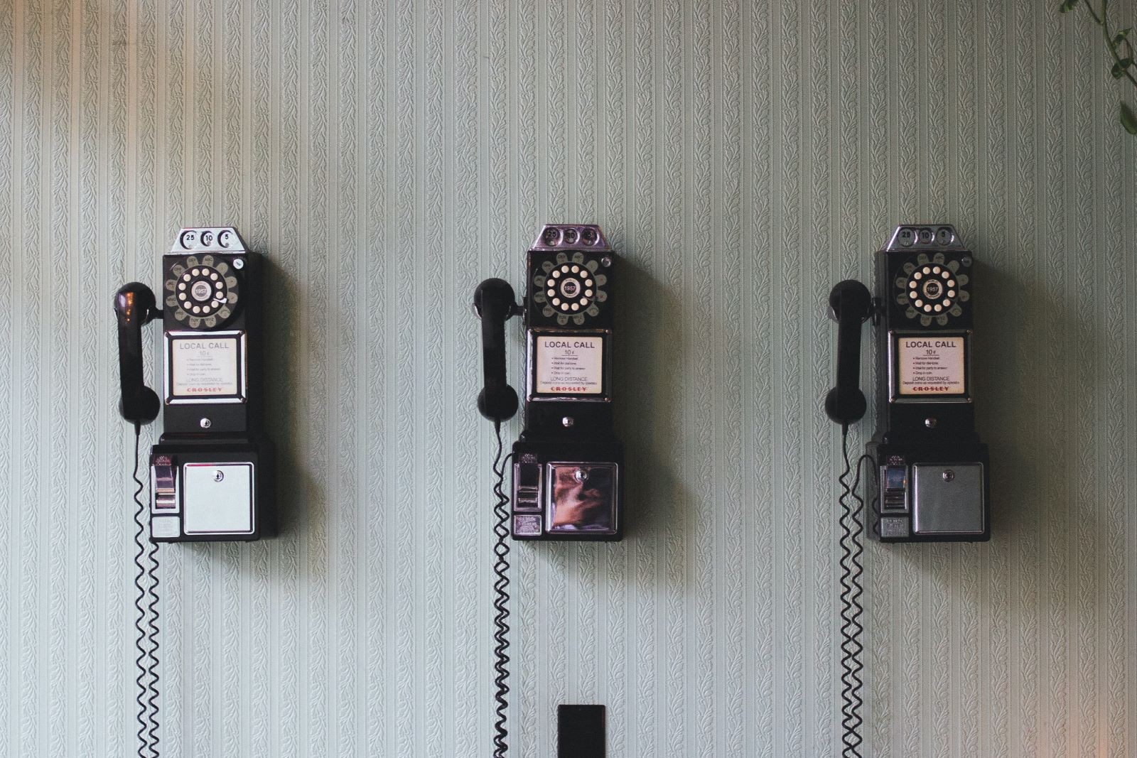 Τηλέφωνα παλιάς τεχνολογίας κρεμασμένα στον τοίχο